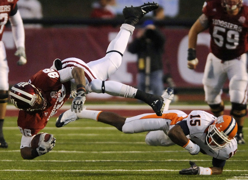 IU wide receiver Damarlo Belcher tumbles to the ground with the ball after a tackle by Illinois cornerback Walter Aikens during a football game on Saturday, Oct. 17, 2009, at Memorial Stadium. IU won 27-14.