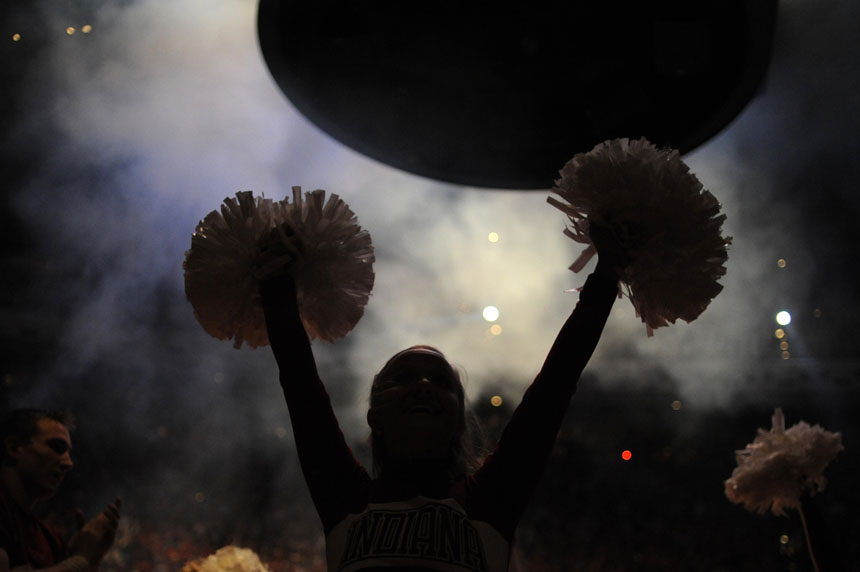An Indiana cheerleader is seen in silhouette after a fireworks display during Hoosier Hysteria on Friday, Oct. 16, 2009, at Assembly Hall in Bloomington, Ind.