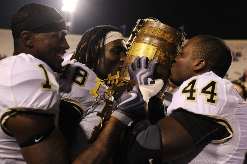 Purdue fullbacks Frank Halliburton (44) and Jared Crank (48) kiss the Old Oaken Bucket as wide receiver Keith Carlos (1) grabs the chain links after the Boilermakers defeated IU 38-21 on Saturday, Nov. 21, 2009, at Memorial Stadium. The win marks the second straight year Purdue has won the bucket game.