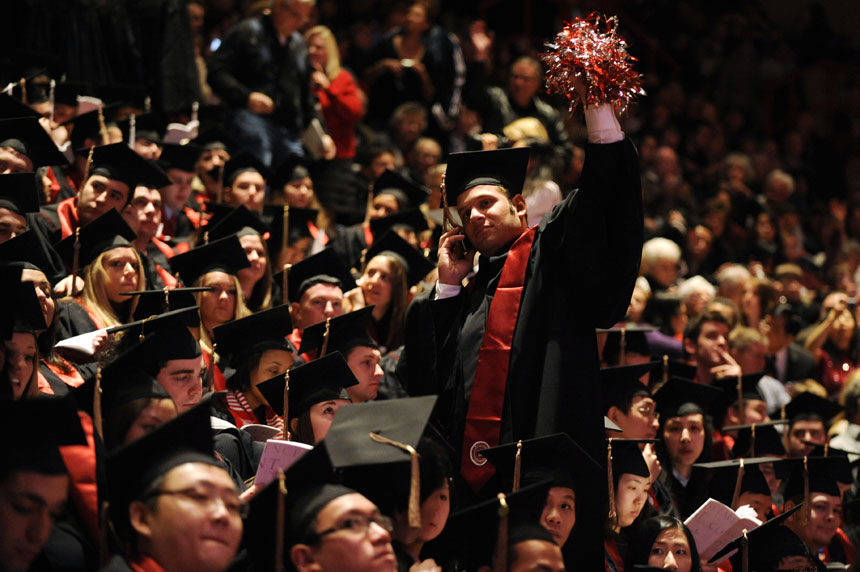 A soon-to-be graduate waves to someone in the crowd from his spot in the stands during IU's Winter Commencement Exercises on Saturday, Dec. 19, 2009, at Assembly Hall.