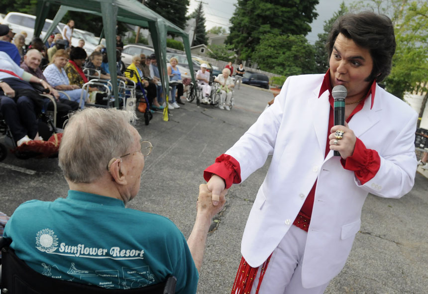 Elvis impersonator Tim Dudley reacts after Forrest F. wouldn't let go of his hand as Dudley greets the crowd during a performance for senior citizens on Friday, June 19, 2009 at the Milton Adult Day Services.