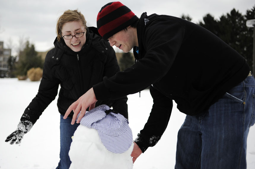 IU freshmen Erin Williams, left, and Jesse Vanhooser work to build a snowman on Saturday, Feb. 6, 2010, in IU's Arboretum. The pair hoped to build a second snowman as a companion to the first.