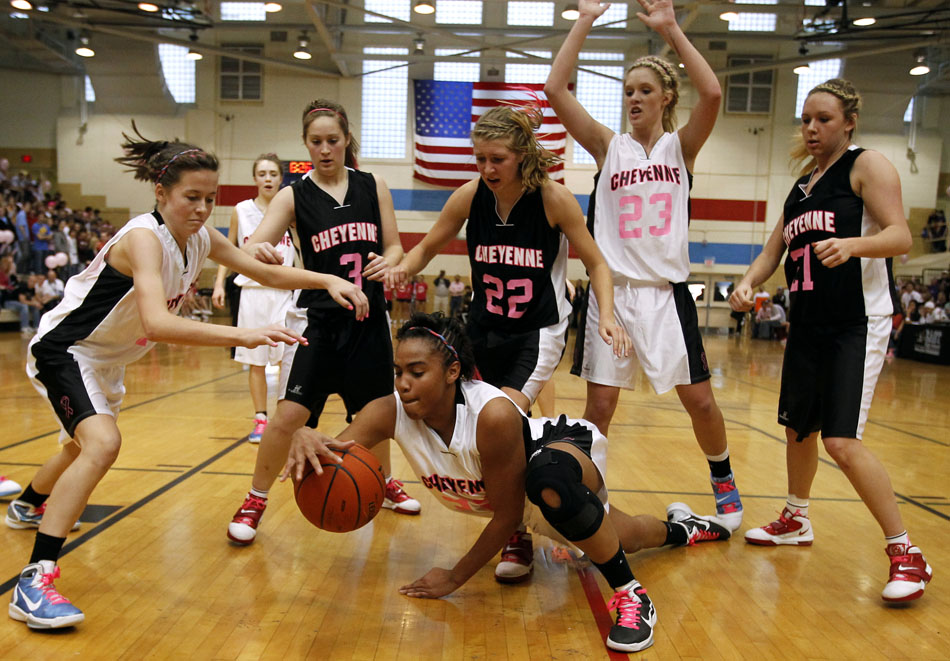 Cheyenne East's Brittany Lawson, middle, dives to the court for a loose ball during  a game against Central on Saturday, Jan. 22, 2011, at Storey Gym. East won 45-39.