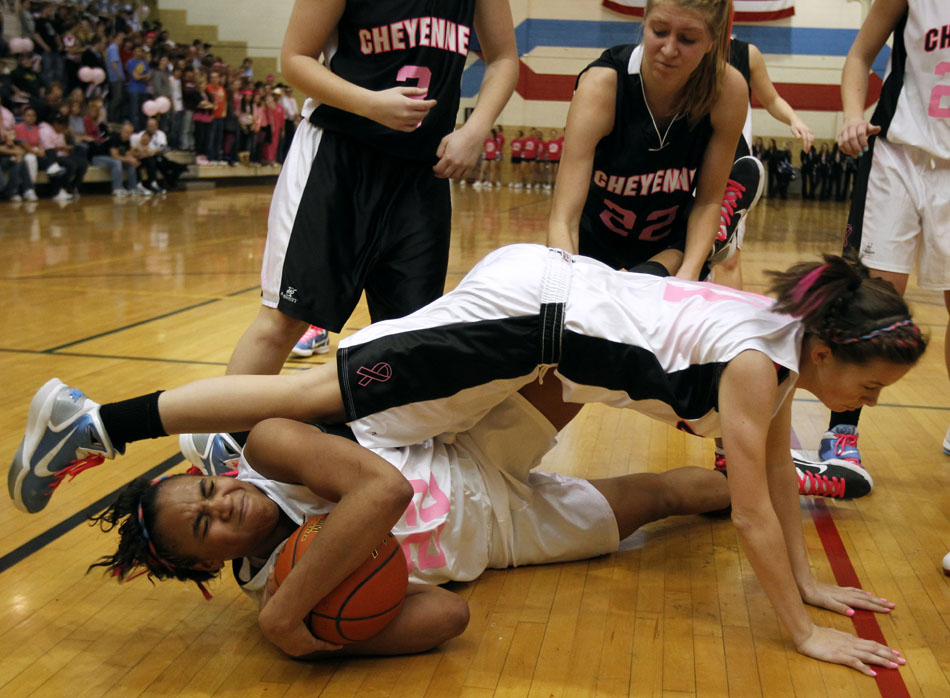 Cheyenne East's Brittany Lawson, left, reacts as teammate Alyssa Diggs falls on her as Lawson corrals a loose ball during a game against Central on Saturday, Jan. 22, 2011, at Storey Gym. East won 45-39.
