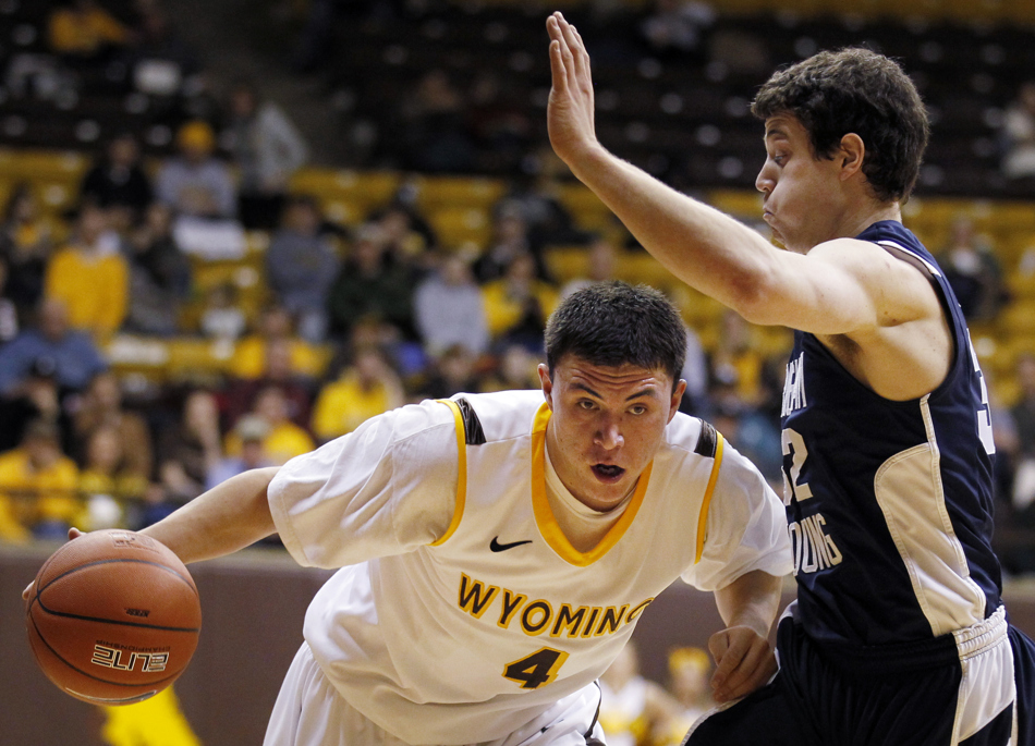 Wyoming guard Francisco Cruz (4) drives past BYU guard Jimmer Fredette (32) during a game on Tuesday, Feb. 2, 2011, in Laramie, Wyo. BYU won 69-62.