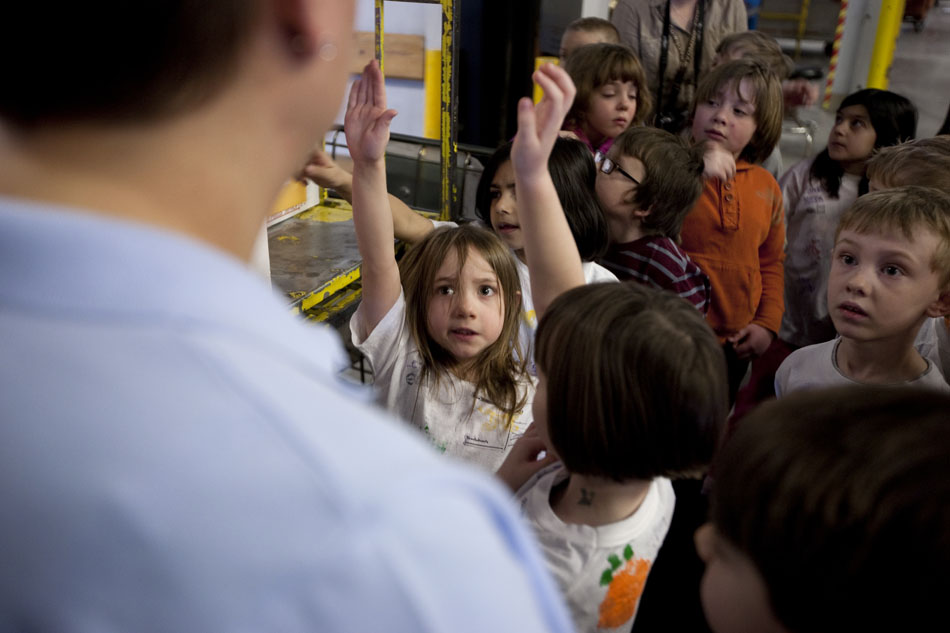 A few youngsters raise their hands to ask a question as Lynette Tafoya, a clerk at the U.S. Postal Office, gives a tour of the facility to more than 30 first graders from Buffalo Ridge Elementary on Wednesday, Feb. 9, 2011, at the Converse Avenue facility in Cheyenne.