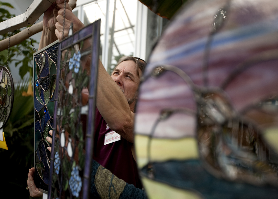 Craig McCune adjusts a hanging piece of artwork after it was hanged backwards during the US Bank Glass Art Celebration on Thursday, Feb. 10, 2011, at the Cheyenne Botanic Gardens.