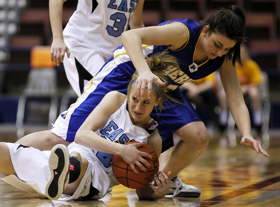 Cheyenne East's Anna Reiner grabs a loose ball on the court, drawing contact from Sheridan's Brianna Smith during a Class 4A girl's basketball semi-final on Friday, March 11, 2011, in Casper, Wyo.