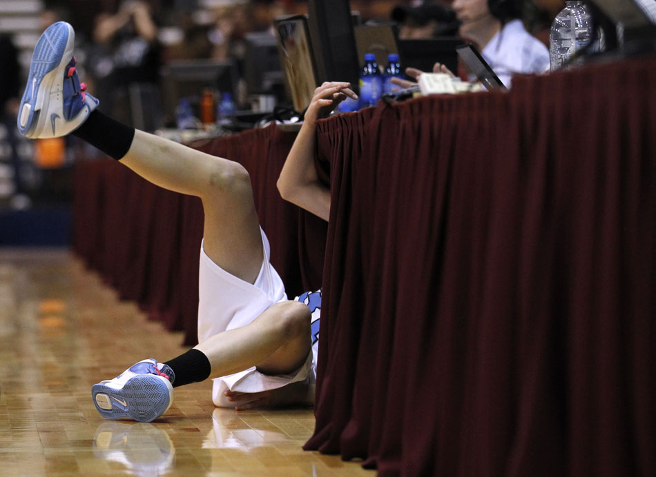 Cheyenne East's Rachel Erickson flies under a media table after diving out of bounds to knock a loose ball back into play during a Class 4A girl's basketball semi-final on Friday, March 11, 2011, in Casper, Wyo.
