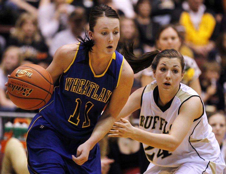 Wheatland's Chelsey Mudgett (11) dribbles past Buffalo's Dallas Shaw (24) during the Class 3A girl's basketball state championship game on Saturday, March 12, 2011, in Casper, Wyo.