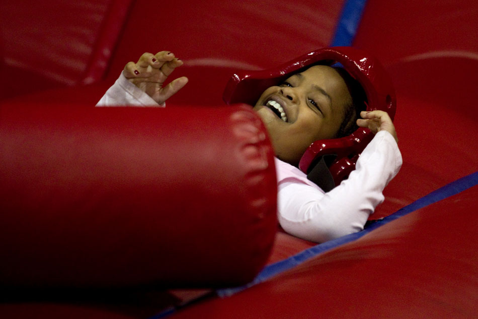 Alivia St. Germain, 8, laughs after falling backwards off a pedestal after battling her brother in a gladiator-type game during the city-sponsored spring carnival on Wednesday, April 20, 2011, at the Cheyenne Ice and Events Center.