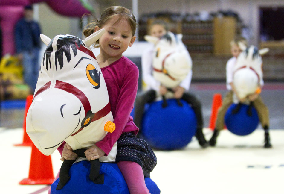 Talia Favreau, 5, crosses the finish line first in front of her competitors, seen in background, in an inflatable horse race during the city-sponsored spring carnival on Wednesday, April 20, 2011, at the Cheyenne Ice and Events Center.