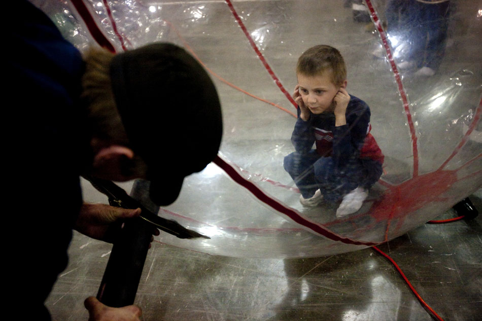 Ricky Bartlett, 7, covers his ears as a worker inflates a plastic ball with air using a leaf blower before a race during the city-sponsored spring carnival on Wednesday, April 20, 2011, at the Cheyenne Ice and Events Center.