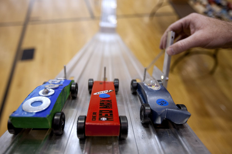 Volunteer Kris Green prepares to pull the lever to release pinewood derby cars in a heat on Saturday, April 23, 2011, at Storey Gym.