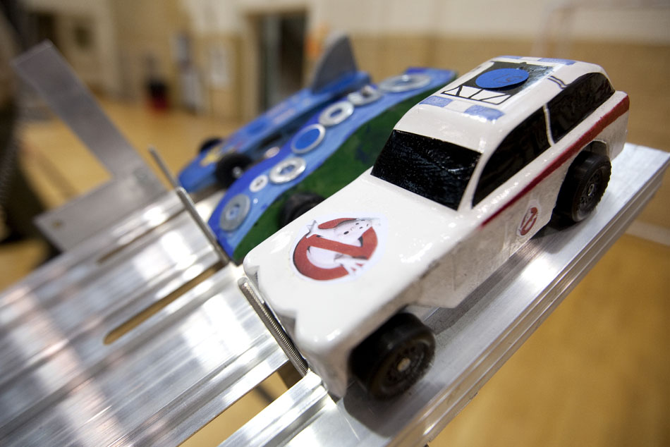 A pinewood derby car resembling the ambulance from the movie "Ghostbusters" sits on the track before a heat on Saturday, April 23, 2011, at Storey Gym.