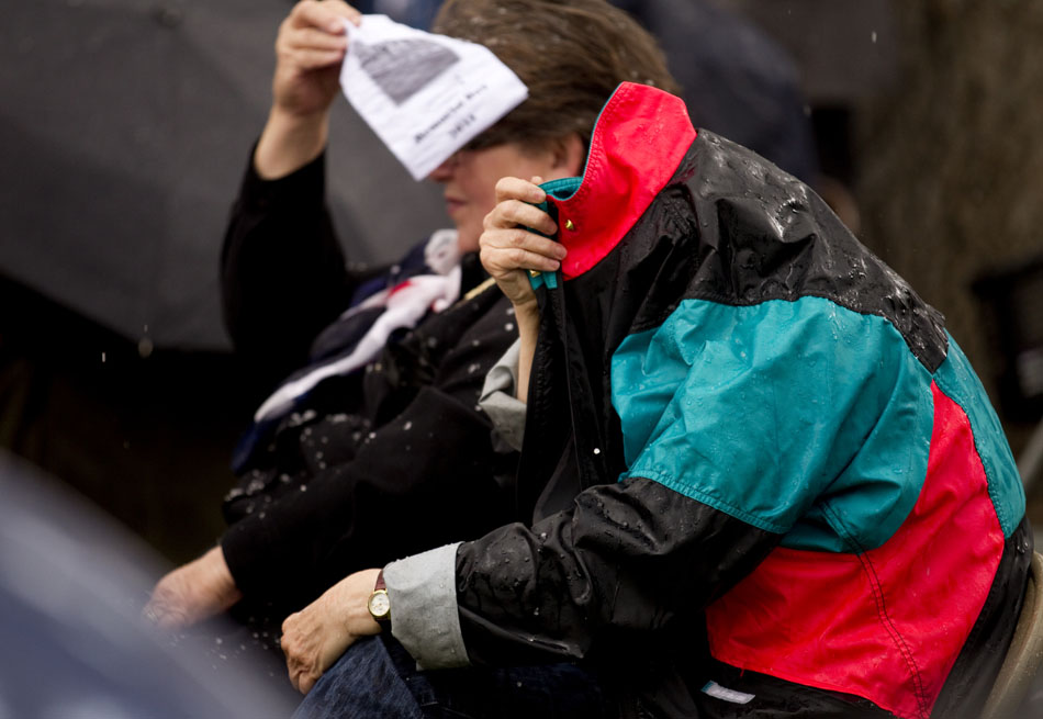 Spectators cover up to shield themselves from the hail during a Memorial Day ceremony on Monday, May 30, 2011, at Beth El Cemetery in Cheyenne.
