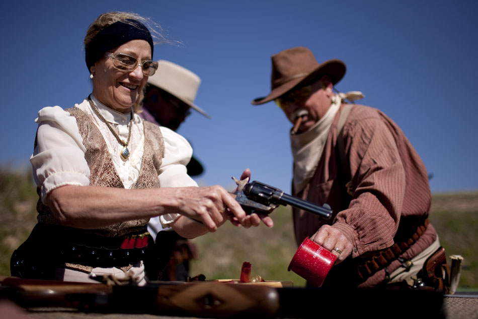 Vicki Martin, of Lakewood, Colo., unloads her .44-caliber revolver after shooting a round during a cowboy shoot on Saturday, June 4, 2011, at the Regulators Range west of Cheyenne. Martin is a member of the Cheyenne Regulators, a group of people who dress in old west period costumes and compete in shooting competitions using weapons commonly used in the old west.