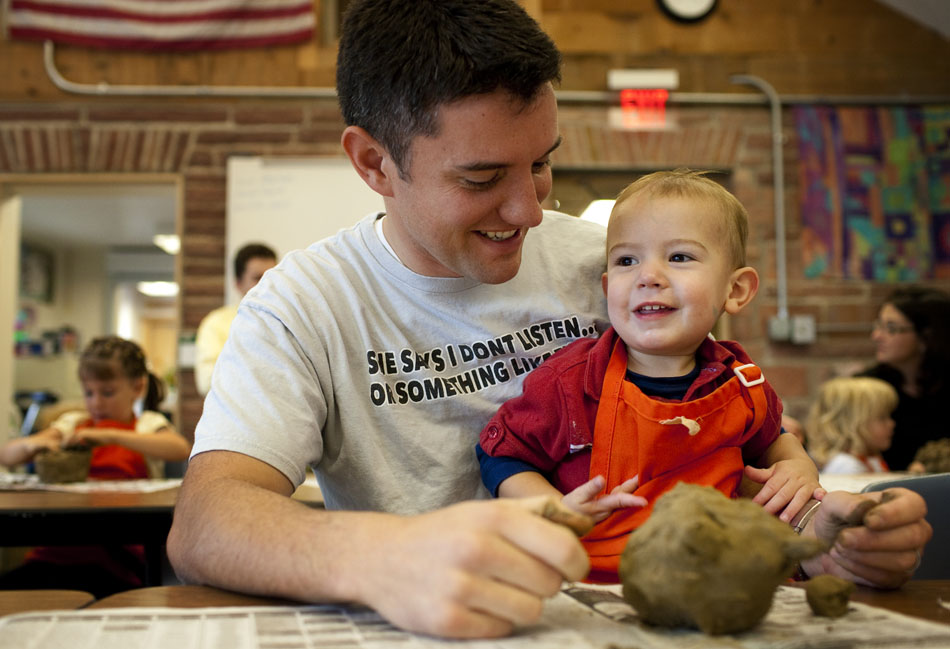 Logan Esplin, right, 1, shares a laugh with his dad, Joe, as they shape a piece of clay into a pig's head during a mud sculpting activity on Wednesday, Sept. 7, 2011, at the Paul Smith Children's Village at the Botanic Gardens. The two were joined by several families and youngsters who created everything from horses to hearts to bowls out of clay.