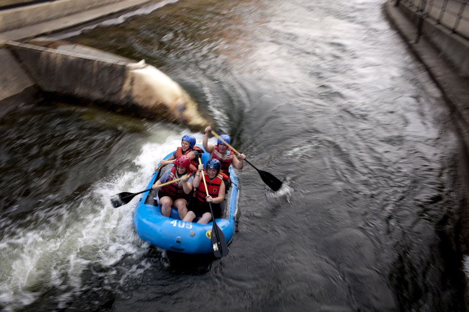 A team of rafters from the Young Professionals Network makes its way down the East Race Waterway on Tuesday, July 17, 2012, in downtown South Bend. (James Brosher/South Bend Tribune)