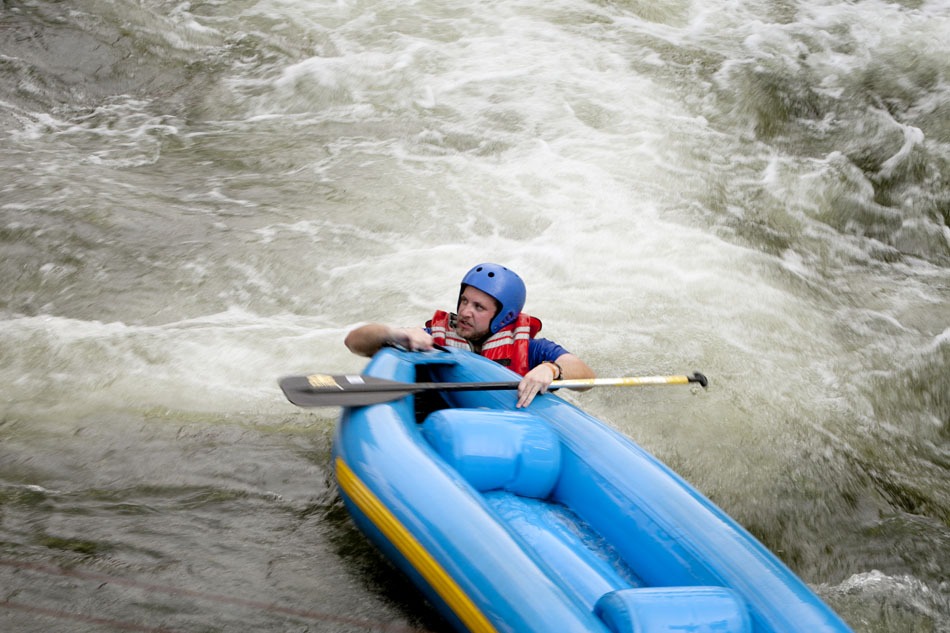 A rafter holds on after being tossed in a rapids section of the East Race Waterway on Tuesday, July 17, 2012, in downtown South Bend. (James Brosher/South Bend Tribune)